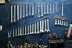 Collection of various Ampco non-sparking wrenches and hand tools neatly arranged on a dark, textured surface, showcasing the breadth of a professional non-sparking toolkit.